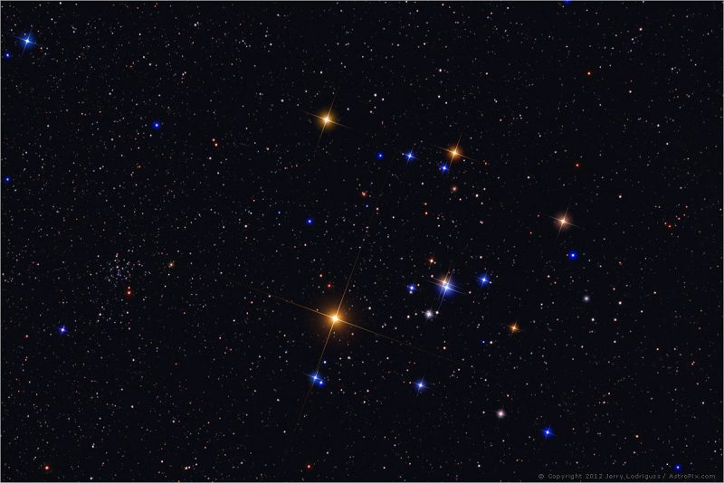 Spread-out cluster of bright multicolored stars, the 5 brightest arranged in a sideways V.