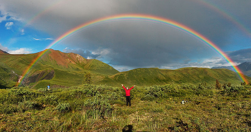 Triple and quadruple rainbows: Man stands under double rainbow.