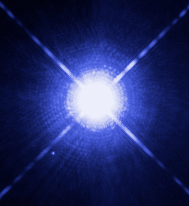 Huge brilliant blue-white star with lens flare rays coming out of it and tiny white dot next to it.