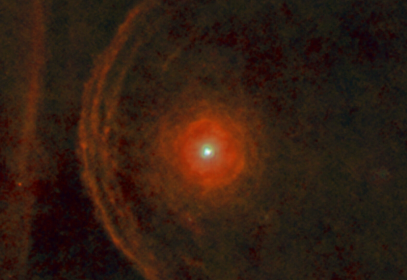 A fuzzy red star, surrounded by a red shell and several fuzzy red arcs.