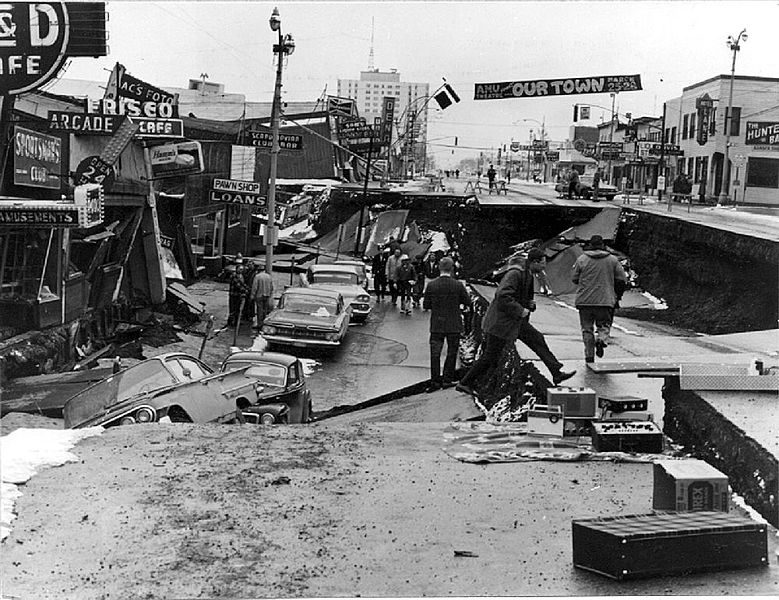 Street with many huge cracks, a large section about a man's height lower than the rest.