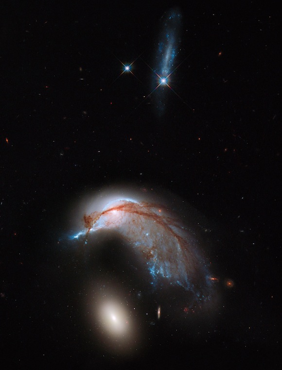 This image shows the two galaxies interacting. NGC 2936, once a standard spiral galaxy, and NGC 2937, a smaller elliptical, bear a striking resemblance to a penguin guarding its egg. This image is a combination of visible and infrared light, created from data gathered by the NASA/ESA Hubble Space Telescope Wide Field Planetary Camera 3 (WFC3).