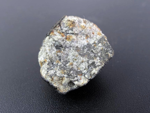 A cut-open Chelyabinsk specimen shows a light texture with darker patches of shocked or impact-melted minerals. When meteorite minerals like olivine are shocked by impact, chemical changes occur that make them darken. Photo by meteorite hunter Evgenij Suhanov. Photo and caption via AstroBob.