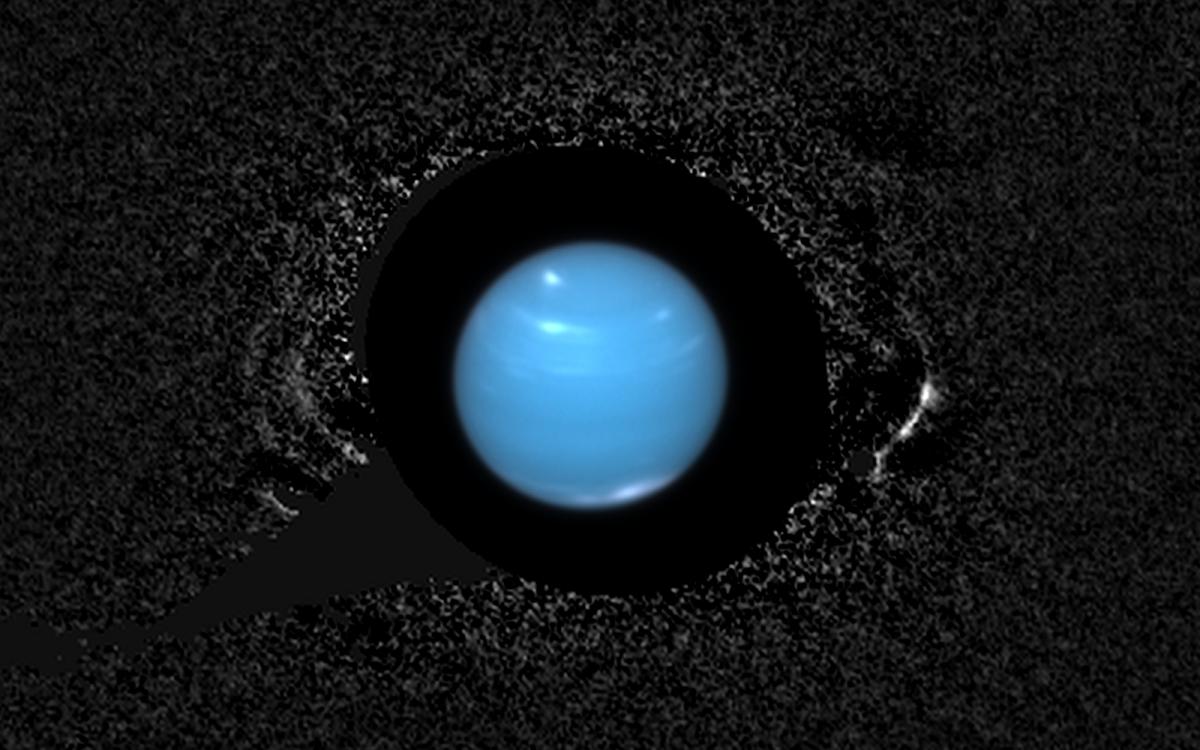 View larger. | Neptune's slender rings are seen with remarkable clarity in this composite image taken by the Hubble Space Telescope in 2004. Astronomers only recently developed the image processing techniques needed to suppress the planet's intense glare and make this view possible. This image is composed of 26 individual exposures, which have been combined to produce the equivalent of a single 95-minute exposure. Image and caption via SETI Institute.
