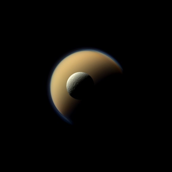 Saturn's largest and second largest moons, Titan and Rhea, appear to be stacked on top of each other in this true-color scene from NASA's Cassini spacecraft. Image via NASA/JPL-Caltech/Space Science Institute. 