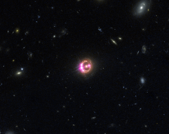 Multiple images of a distant quasar are visible in this combined view from NASA’s Chandra X-ray Observatory and the Hubble Space Telescope. The Chandra data were used to directly measure the spin of the supermassive black hole powering this quasar. Credit: X-ray: NASA/CXC/Univ of Michigan/R.C.Reis et al; Optical: NASA/STScI