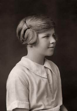 Portrait of little girl with very short hair held with a barrette.