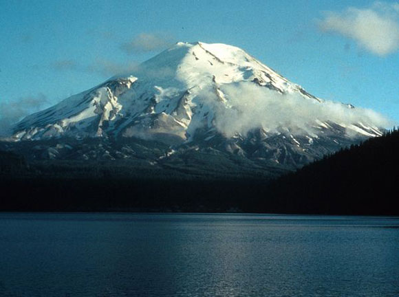 Snowcapped mountain with water in foreground.
