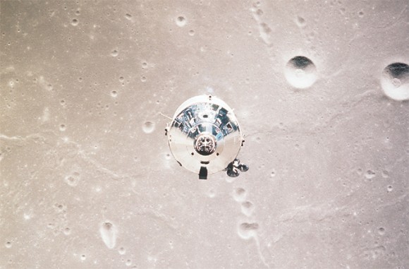 End view of shiny, metallic conical module against light tan lunar surface with craters.