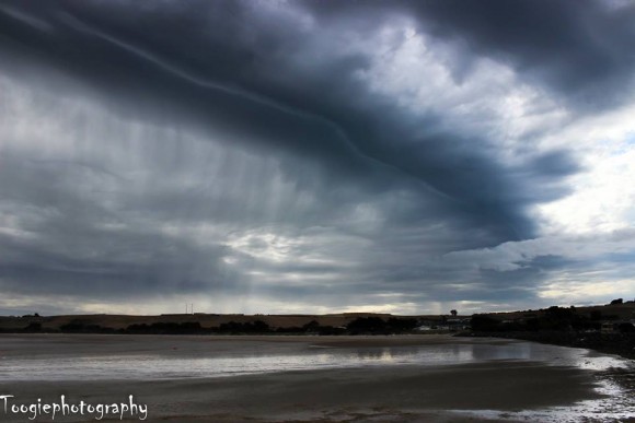 Shelf cloud above a beach.