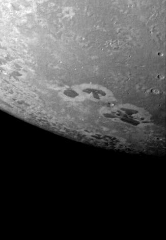 Dark patches on Triton.  Image via Voyager 2