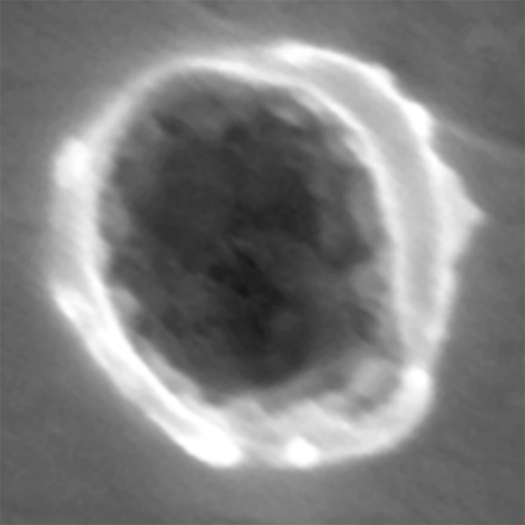  A top-down scanning electron microscope view of one of the interstellar dust impacts (1061N,3) in the foil aboard the Stardust spacecraft. The crater is about 280 nanometers across; 400 of these craters would span the width of a human hair. The dust particle residue is visible as the 