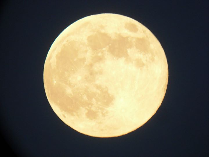 Large, bright, yellow moon against a black background