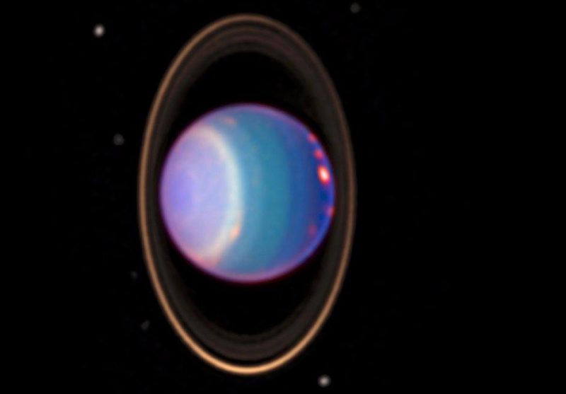 Lyseblå planet på sin side med lodrette ringe.falsk farvebillede af Uranus-viser lyse skyer langs ækvator - ved hjælp af Hubble - Rumteleskopdata taget den 8. August 1998. Via NASA JPL / Erich Karkoschka.