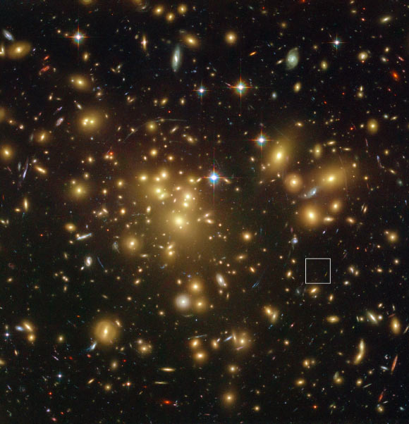 This is the galaxy cluster Abell 1689.  It's so massive that its gravity bends and magnifies light coming  from more distant objects beyond it. That's how we can see the galaxy A1689-zD1 (in box). It’s a dusty galaxy seen when the universe was just 700 million years old. Image via NASA / ESA / L. Bradley, H. Ford, R. Bouwens, G. Illingworth.
