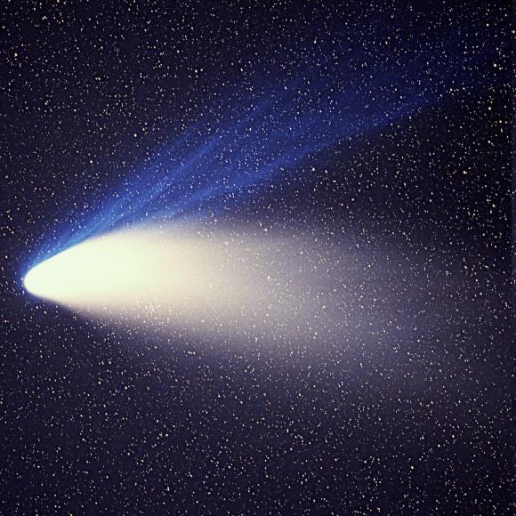 Large glowing V-shape, the comet and its dust tail, with narrower blue tail extending at an angle.