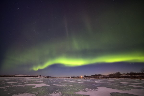 A ribbon of green light over a snowy prairie.