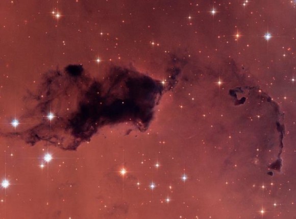This Hubble image features dark knots of gas and dust known as 