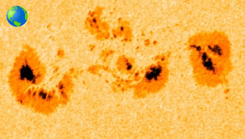 Earth compared to sunspot group AR 2339.  Image via SkyandTelescope.com