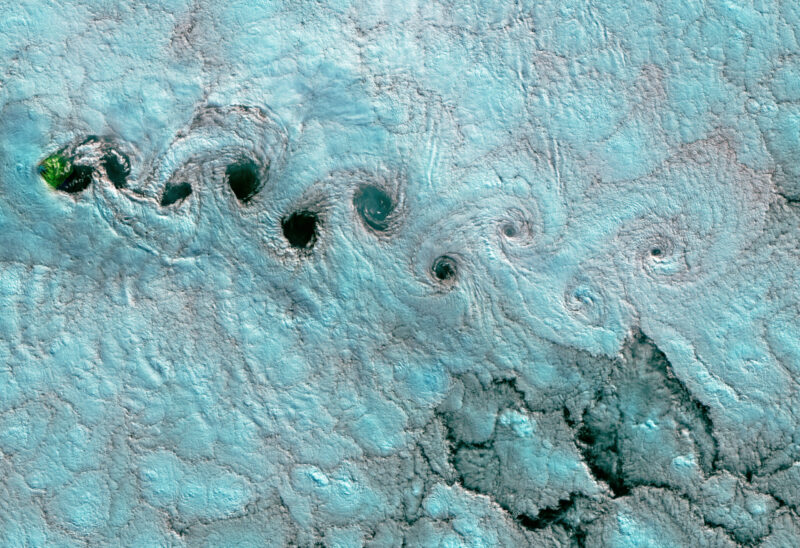 Bluish patches with darker see-through areas where the center of clouds allows you to see to the ocean.