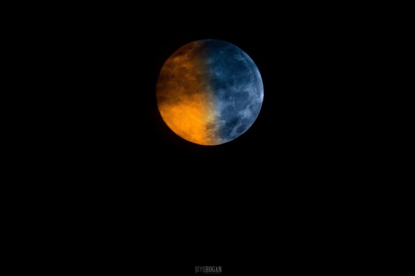 Полная луна наполовину синяя, наполовину оранжевая.