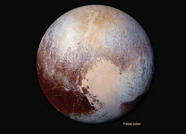 View larger. | Four images from New Horizons’ Long Range Reconnaissance Imager (LORRI) were combined with color data from the Ralph instrument to create this enhanced color global view of Pluto. (The lower right edge of Pluto in this view currently lacks high-resolution color coverage.) The images, taken when the spacecraft was 280,000 miles (450,000 km) away, show features as small as 1.4 miles (2.2 km). Image via NASA/JHUAPL/SwRI.