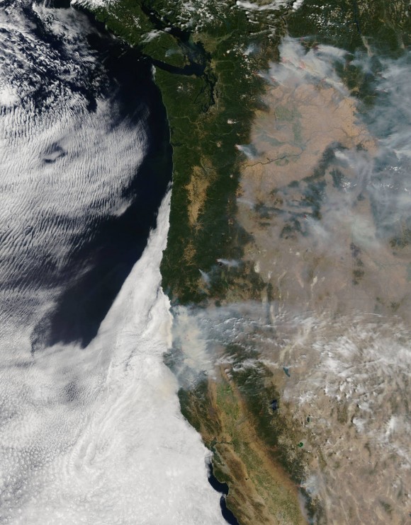 NASA's Aqua satellite collected this natural-color image with the Moderate Resolution Imaging Spectroradiometer, MODIS, instrument on August 19, 2015. Actively burning areas, detected by MODIS’s thermal bands, are outlined in red. Image credit: Jeff Schmaltz LANCE/EOSDIS MODIS Rapid Response Team, GSFC