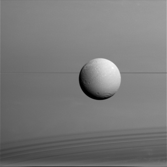 Dione hangs in front of Saturn and its icy rings in this view, captured during Cassini's final close flyby of the icy moon. Image credit: NASA/JPL-Caltech/Space Science Institute
