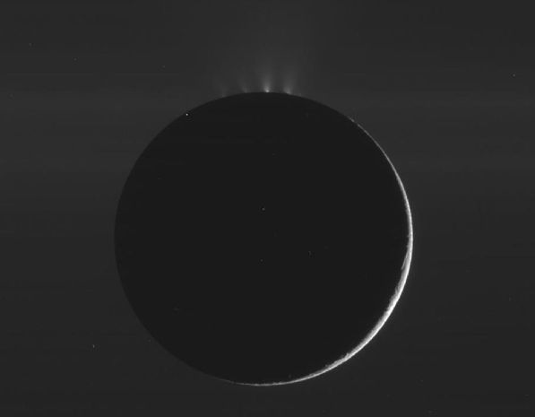 Cassini spacecraft image from 2010 of Saturn's moon Enceladus.  The moon is backlit, with its dark outline crowned by glowing jets from the south polar region.  Notice that there are several separate jets, or sets of jets, emanating from the fissures known to scientists as 