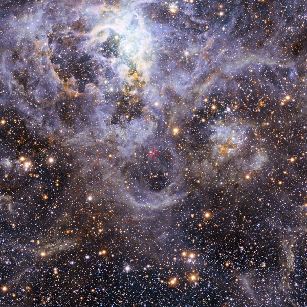 This image shows the location of VFTS 352 — the hottest and most massive double star system to date where the two components are in contact and sharing material. The two stars in this extreme system lie about 160 000 light-years from Earth in the Large Magellanic Cloud. This intriguing system could be heading for a dramatic end, either merging to form a single giant star or forming a binary black hole. This view of the Tarantula star-forming region includes visible-light images from the Wide Field Imager at the MPG/ESO 2.2-metre telescope at La Silla and infrared images from the 4.1-metre infrared VISTA telescope at Paranal. Image via ESO