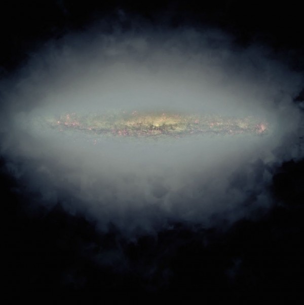 Composite image of an edge-on spiral galaxy with a radio halo. In this image, the large, grey-blue area is a composite of the radio halos of 30 different galaxies,. At the center is a visible-light image of one of the galaxies, NGC 5775. This visible-light image shows only the inner part of the galaxy's star-forming region, outer portions of which extend horizontally into the area of the radio halo.  Image via Jayanne English, Judith Irwin and Theresa Wiegert ; CHANG-ES consortium, NRAO/AUI/NSF; NASA/STScI