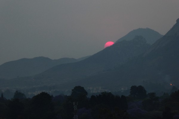 Setting sun colored magenta by smoke haze, Mutare, Zimbabwe, October 10. Photo by Peter Lowenstein.