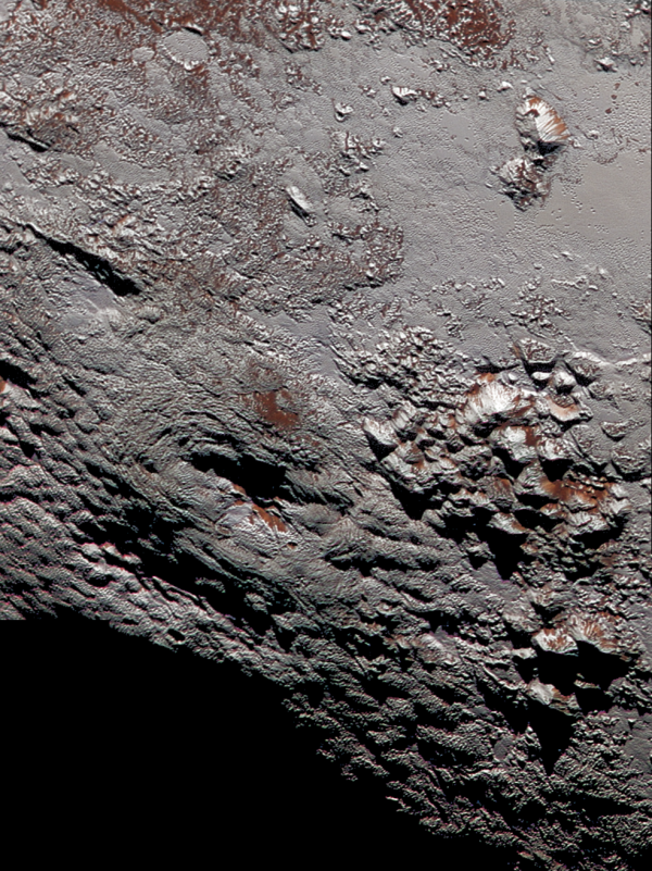 View larger. | This composite image of a possible ice volcano on Pluto includes pictures taken by the New Horizons spacecraft’s Long Range Reconnaissance Imager (LORRI) on July 14, 2015, from a range of about 30,000 miles (48,000 kilometers), showing features as small as 1,500 feet (450 meters) across. Sprinkled across the LORRI mosaic is enhanced color data from the Ralph/Multispectral Visible Imaging Camera (MVIC), from a range of 21,000 miles (34,000 kilometers) and at a resolution of about 2,100 feet (650 meters) per pixel. The entire scene is 140 miles (230 kilometers) across. Credits: NASA/JHUAPL/SwRI