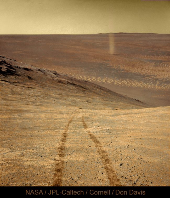 Rover tracks in the foreground, and a dust devil in the background.