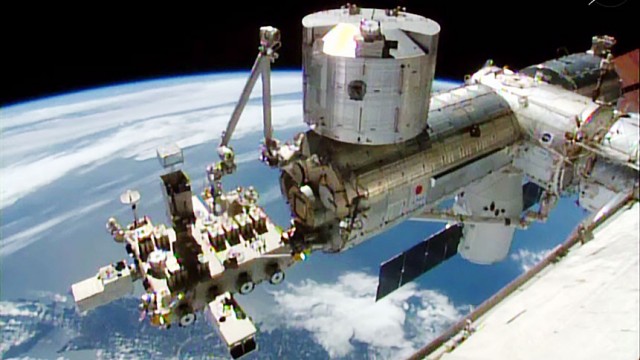 he SpaceX Dragon is in the center right of the image attached to the Harmony module. The Japanese Kibo lab module, with its robotic arm and Exposed Facility, dominates the foreground. Image credit: NASA TV