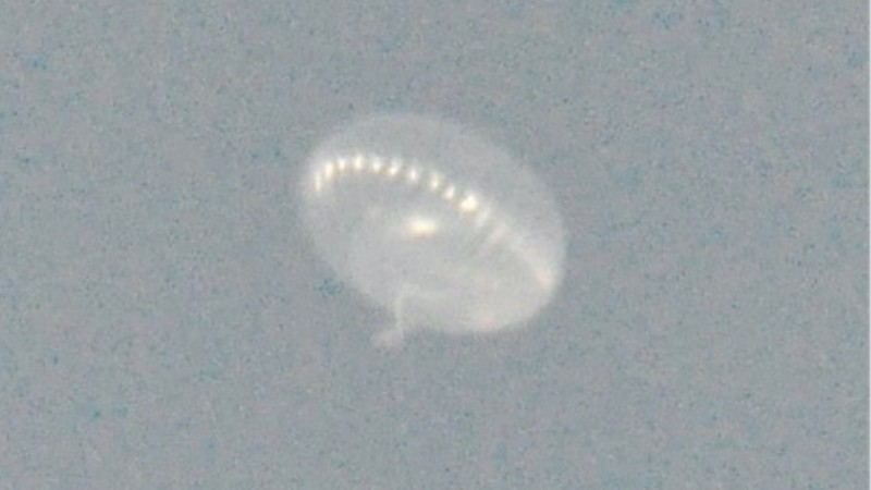 Jellyfish-shaped translucent balloon against a blue sky.