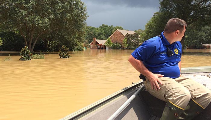 A Livingston Parish deputy sheriff surveys flood damage from a boat on August 15, 2016.  Image courtesy of Rapides County Sheriff's Office 