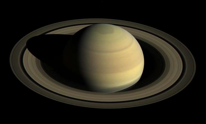 Large, clear, sharp view of large yellowish banded Saturn with many rings.