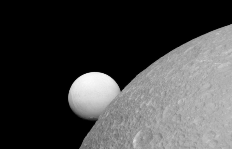 Dione (near) with Enceladus (far) in the background. This image was taken by the Cassini spacecraft on 8 September 2015 Image via NASA/JPL-Caltech/Space Science Institute.