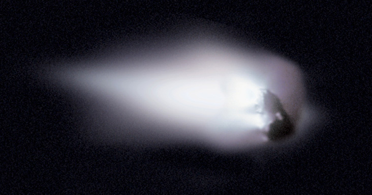 Comet Halley: A globular icy chunk moving in space, surrounded by an oblong cloud of haze.