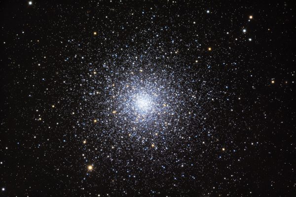 Many bright stars, thick at center of round cluster, becoming less dense with distance from center.