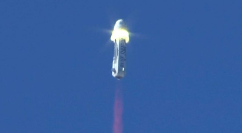 Rocket blasting off into blue sky.