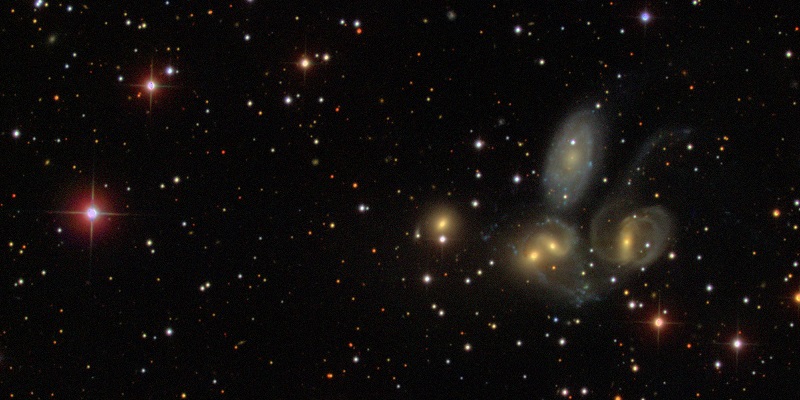Five yellow-centered spiral galaxies in a bunch.
