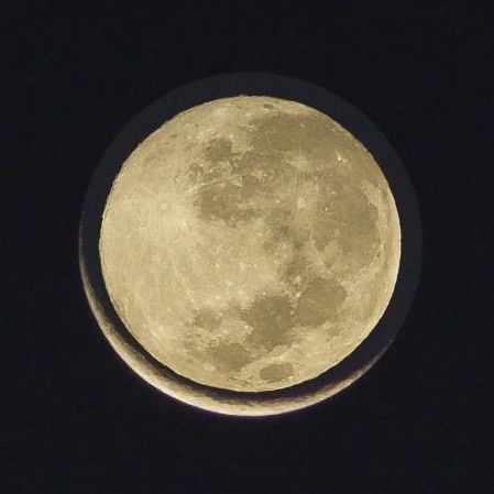 A smaller full moon superimposed on a larger very thin crescent moon.