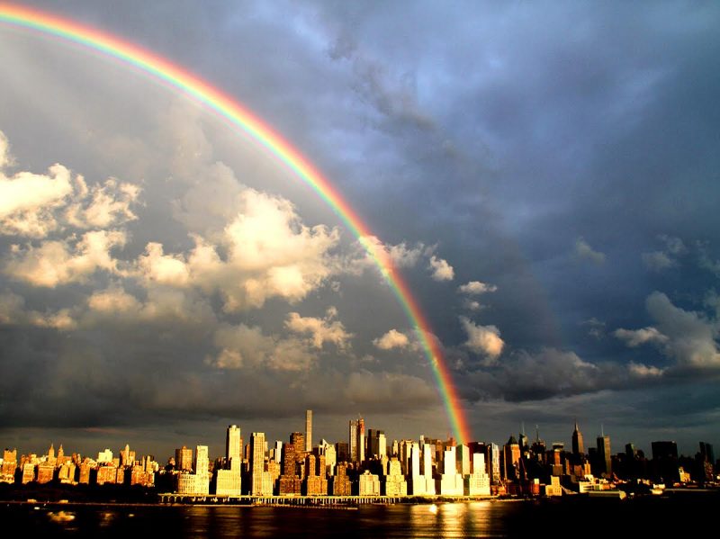 Rainbows, 1 bright and 1 faint, arcing over New York City.