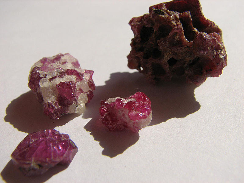 Several small rocks with irregular dark red roundish gems embedded in them.
