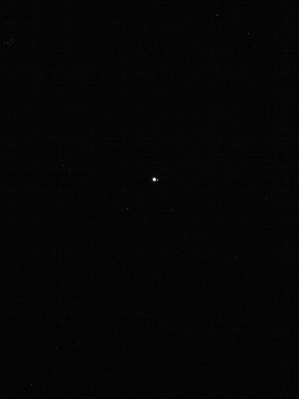 Small white dot on black background with tiny white dot next to it and a few dim stars.