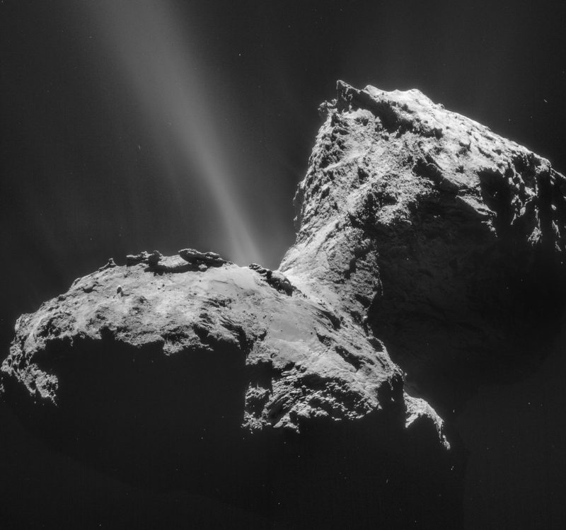 Closeup of rough-surfaced double-lobed comet, with a single stream of gas jetting from it.