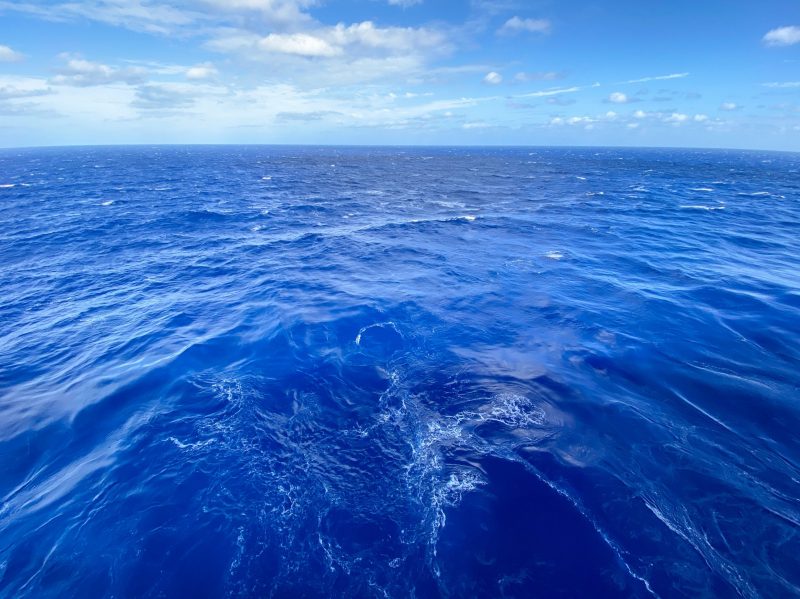 Best ocean photos: Blue ocean, apparently seen from the rear of a boat, under a blue sky.