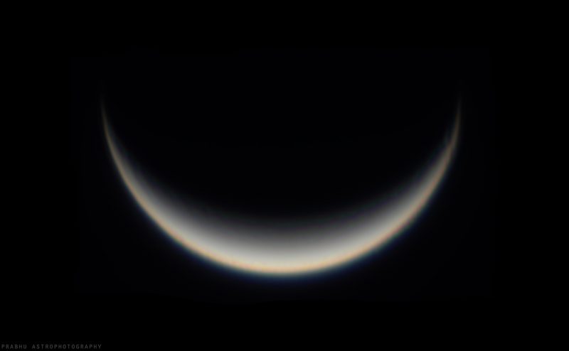 A fuzzy white crescent, pointing downward, on a black background.